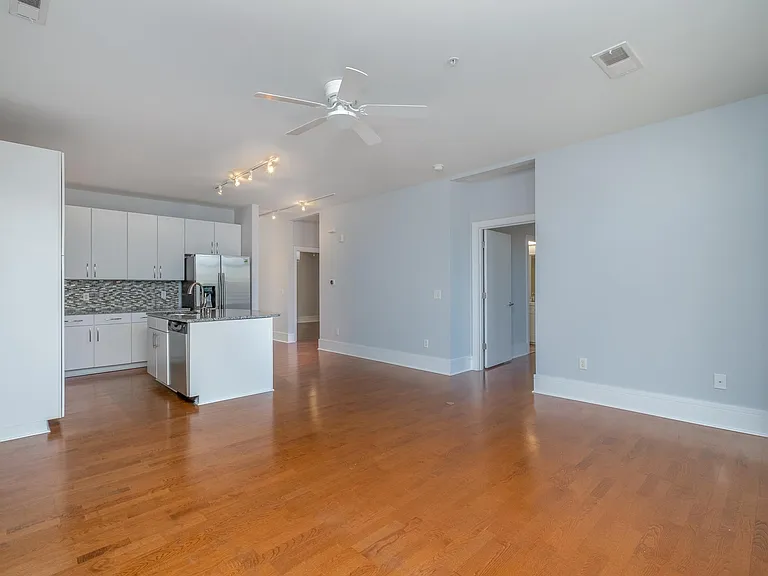 View of the living room and kitchen from the back wall of the condo