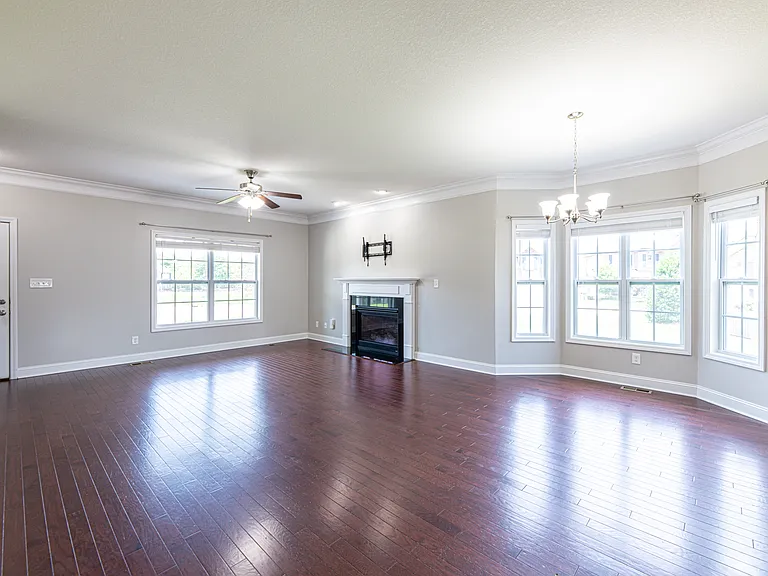 Living room features hardwood floors, a gas fireplace and a heavy-duty TV mount compatible with 42"_90" TVs supporting up to 150 lbs.