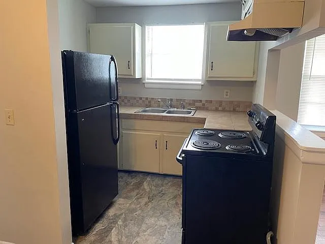 Kitchen with range and refrigerator.