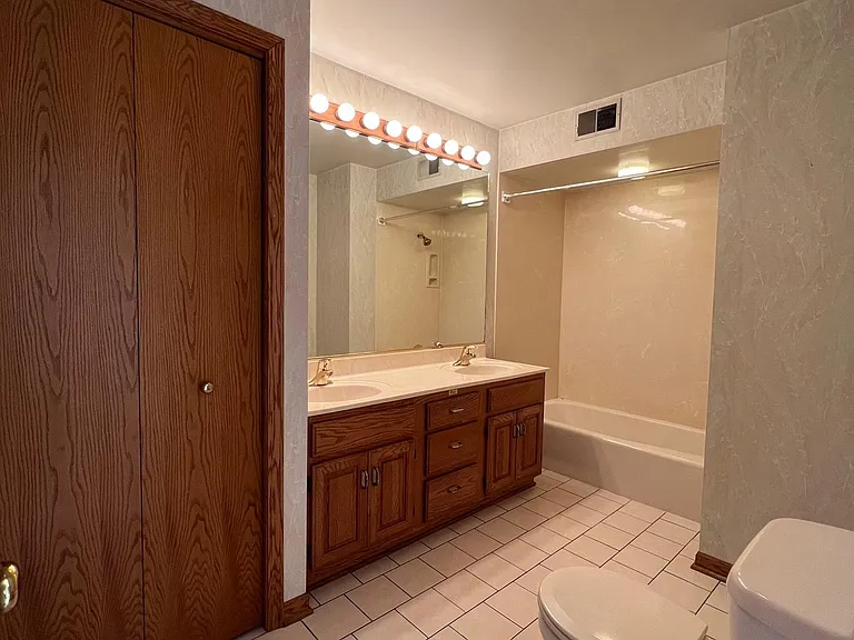 Large bathroom with double bowl sinks and linen closet