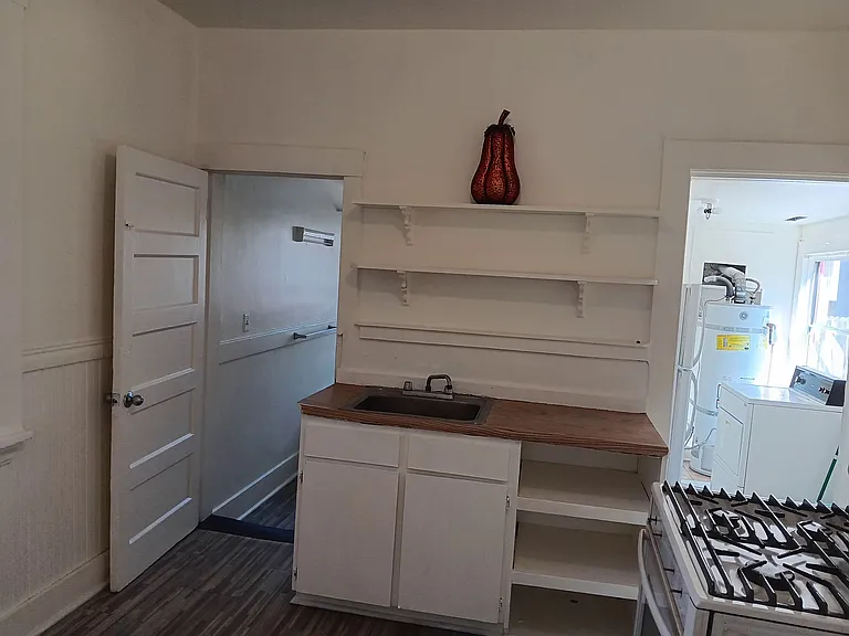 Kitchen with cabinet, shelves, and sink