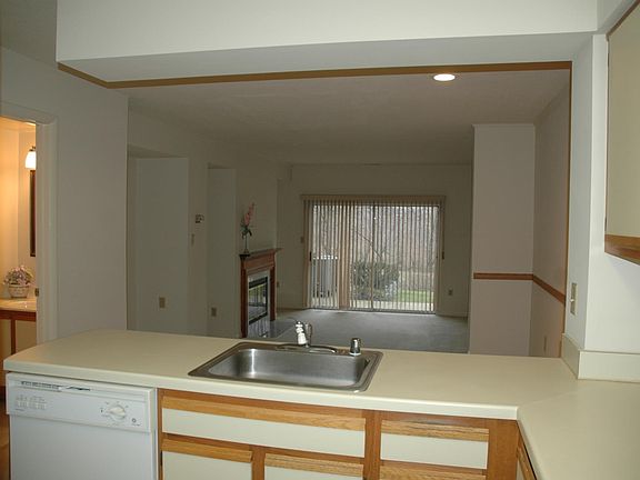 View of powder room, dining room and living room from kitche