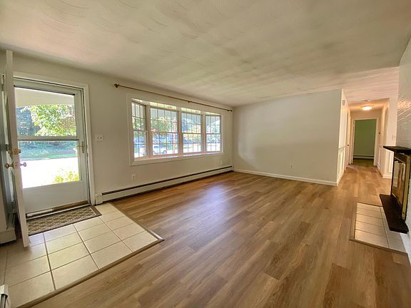 Main entry door into living room. Large bow window with recessed lighting. New laminate wood flooring