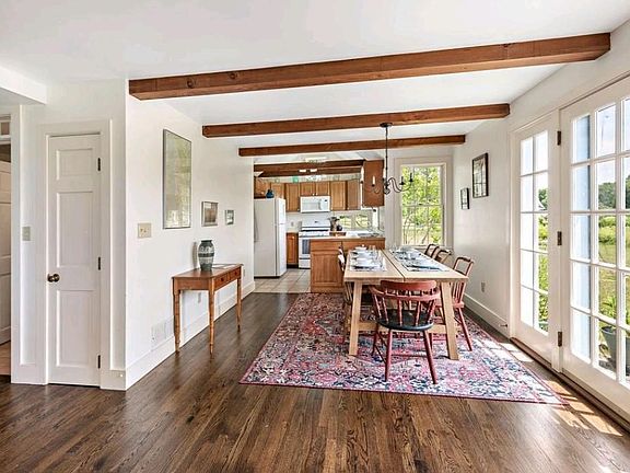 Dining area viewed from living room, kitchen at far end. Door on right leads to stone patio.