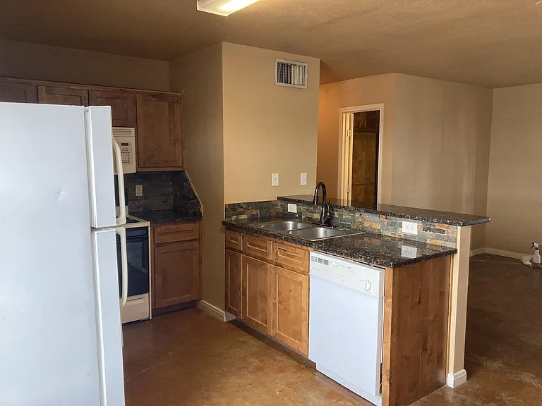From the dining area looking into the kitchen and hallway to the bedrooms. Bathroom door on right