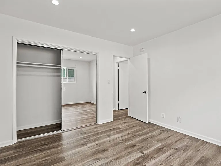 Bedroom with Mirrored Closet, Vinyl Flooring, and Recessed Lighting