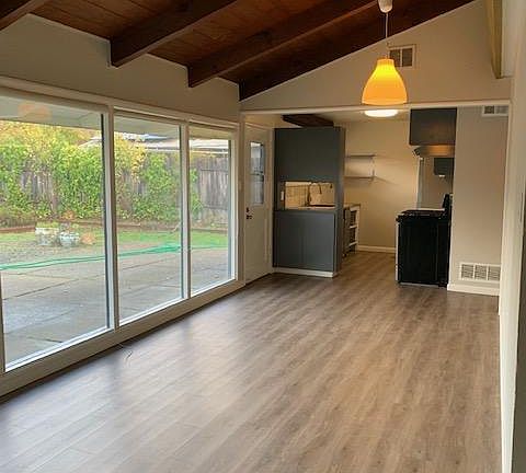 View from the living room to the dining and kitchen. Same hard surface throughout the house for easy living and minimal upkeep.