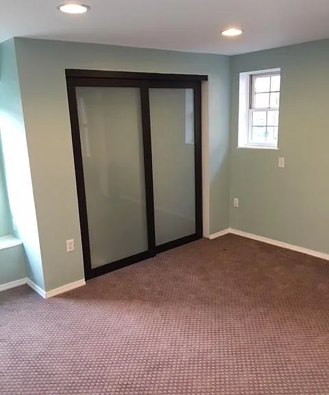 Large sunny bedroom with access to outdoor deck.