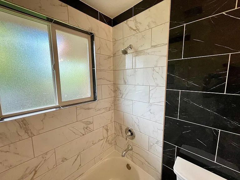 Main floor hallway bathroom with custom tile work.