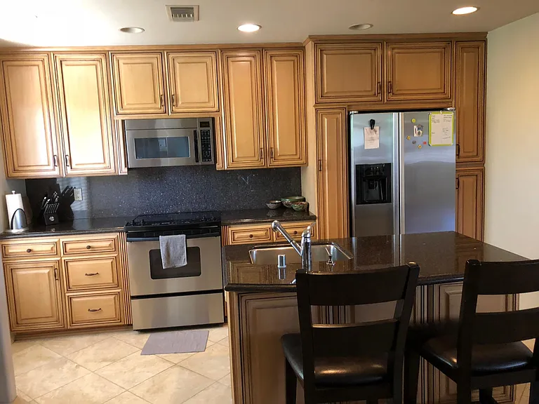 Full Kitchen with stainless steel appliances, dishwasher, stove, oven, microwave, refrigerator, garage disposal, granite counters, custom cabinets, center island with eat-at-counter, open floor plan