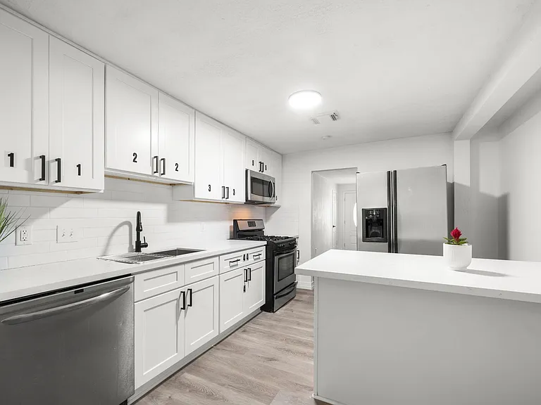 Shared kitchen with labeled cabinets per room.