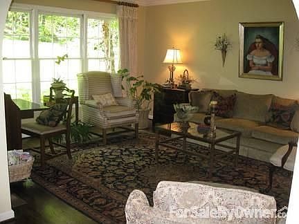 Living room with triple windows and an arched opening from the entryway.