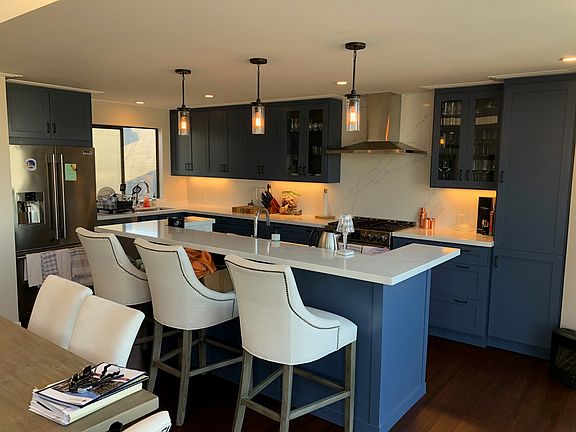 Chef's kitchen with two sinks, stainless steel appliances, wine fridge and high end 5-burner range