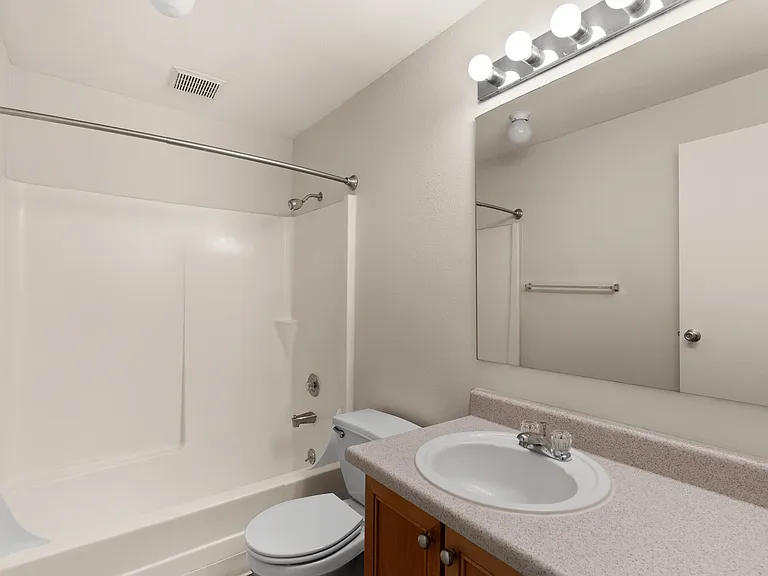 Modern bathroom with a sleek white bathtub, elegant vanity, and bright lighting, offering a comfortable and stylish space. Modern bathroom with a sleek white bathtub, elegant vanity, and bright lighting, offering a comfortable and stylish space.