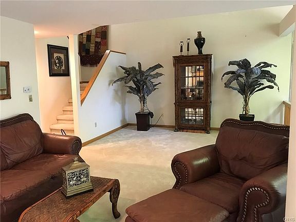 View of the spacious living room looking to the open stairway leading to the upstairs bedrooms