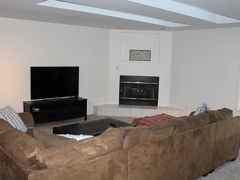 Family room with tv, couch, chair and fireplace