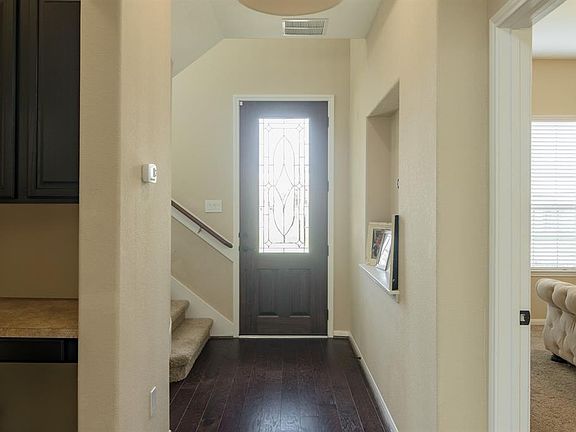 Spacious foyer with staircase on the right and art niche on the left as you enter the home.