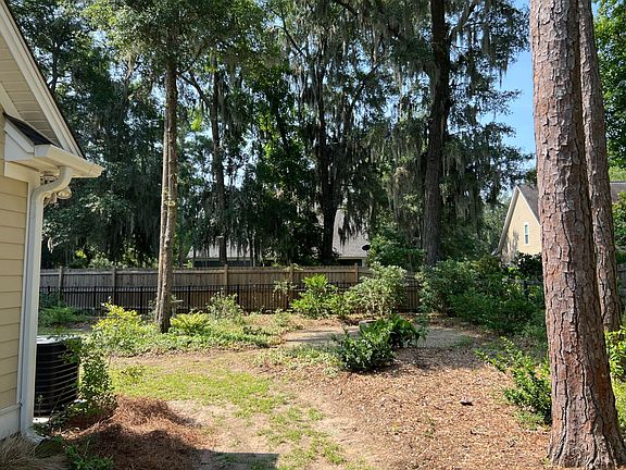 Fence in backyard with plenty of space for swing sets.