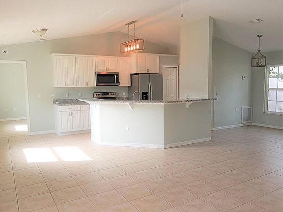 Open floor plan looking from the living room into the kitchen and dining room. Plenty of space at the breakfast bar!