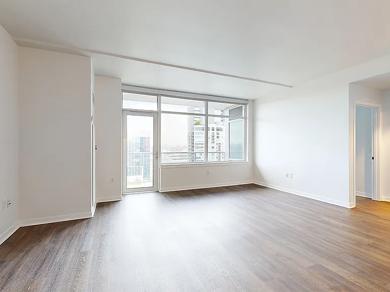 Apartment dining and living room with wood-style flooring.