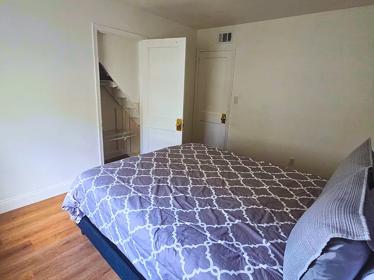 Bright bedroom with a queen bed, premium linens and cozy bedside lamps.