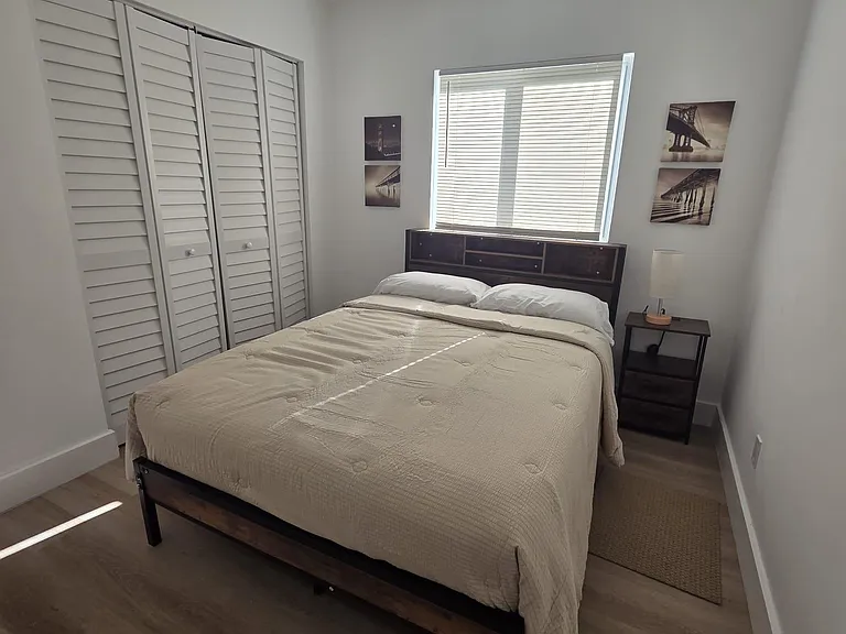 Well-appointed bedroom with a comfortable bed, large closet, and a window with blinds for natural light and privacy.