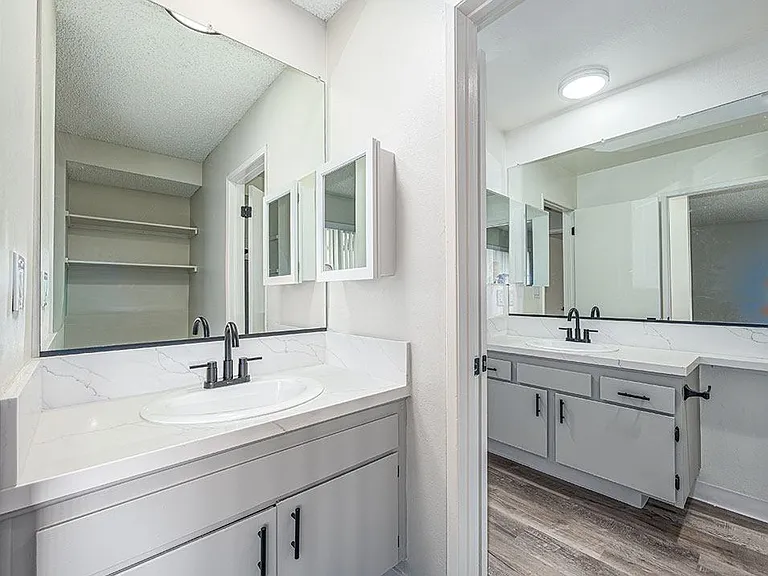 Modern styled bathroom vanity with view to full bathroom.