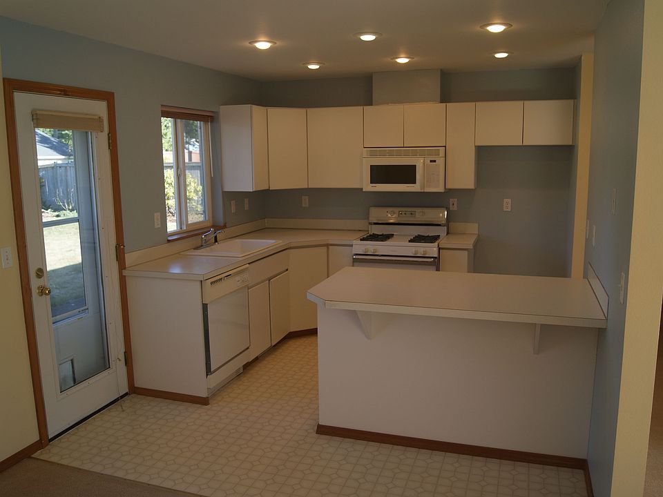 nice clean kitchen with breakfast nook, gas range, paito outside