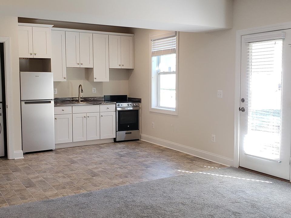 Kitchen with full size refrigerator and washer/dryer.