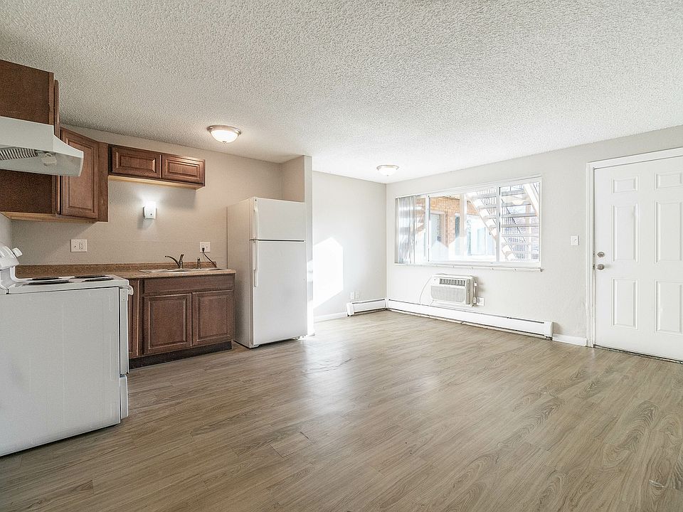 Bright and airy open-plan living space featuring a modern kitchen with elegant wood cabinetry and hardwood floors.
