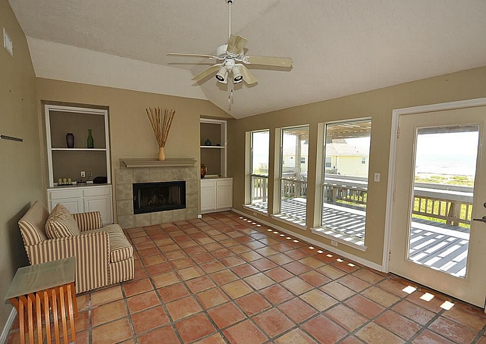 Living area with tile flooring built-ins & fire place.