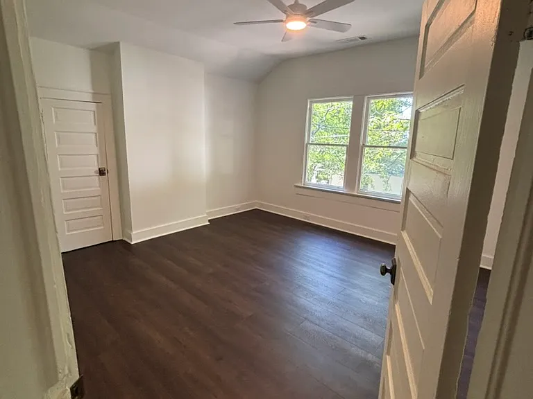 Bedroom 1 with tall ceilings, remote-control fan, built in bookcase and large walk-in closet.