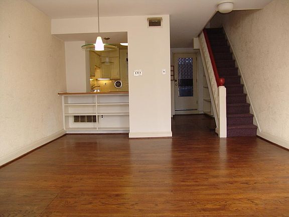 First Floor looking into open floor plan. to combination living/dining area towards kitchen. Back door to small courtyard.