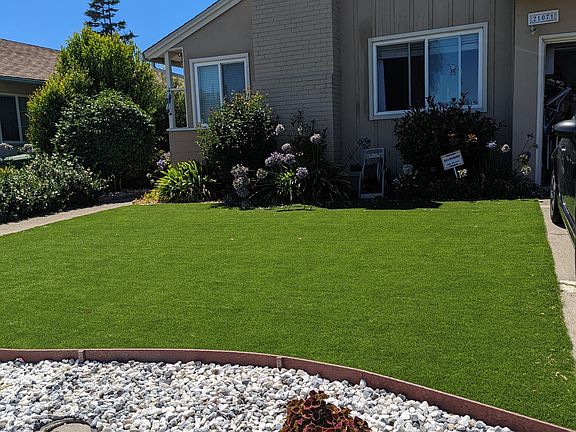 Front yard with low maintenance artificial turf and decorative stones