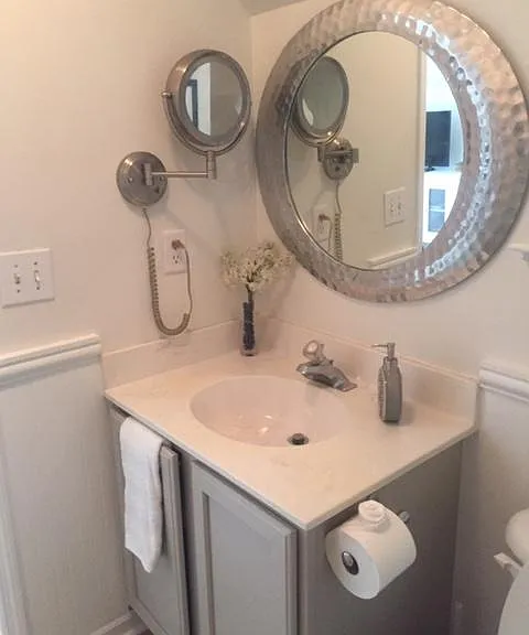 Bath with shower and storage under sink.