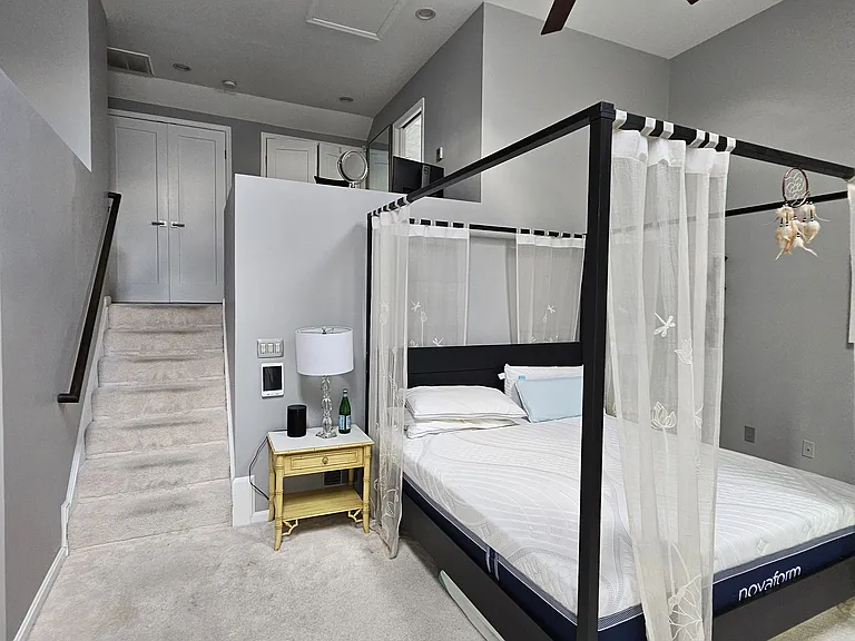 Primary bedroom with stairs leading to primary bathroom