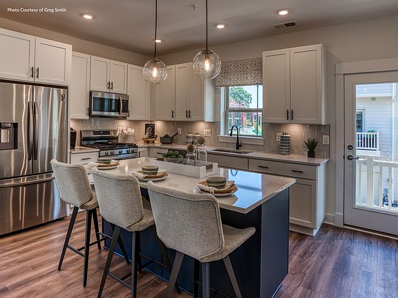 Each kitchen boasts stainless steel appliances and sleek granite countertops.