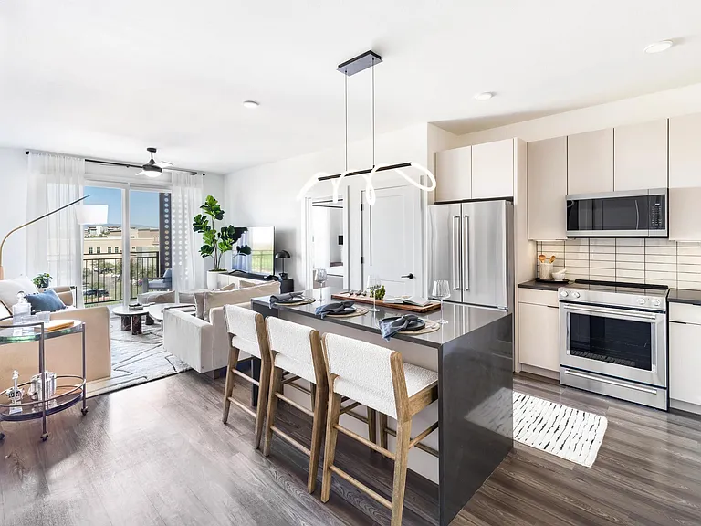 This open-concept layout features a spacious waterfall island perfect for dining or prep, with cabinetry available in multiple designer-selected finish options.