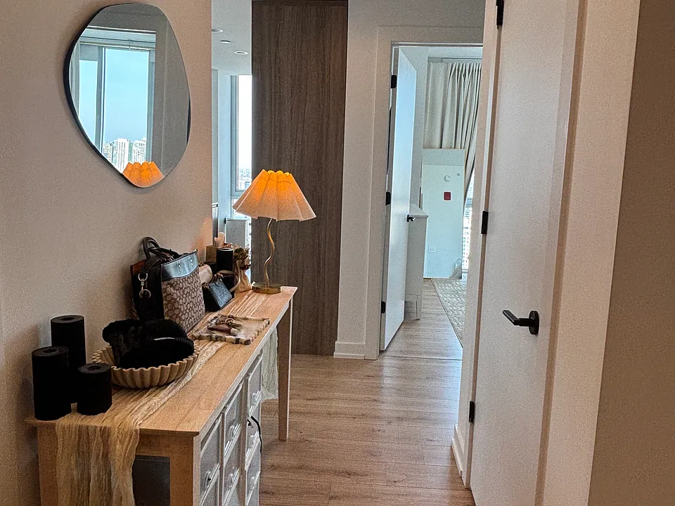 Entryway hallway with coat closet (right) and guest bathroom (left).