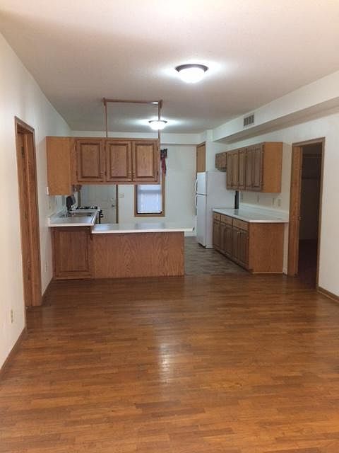 Hardwood floor of living room looking into the kitchen.