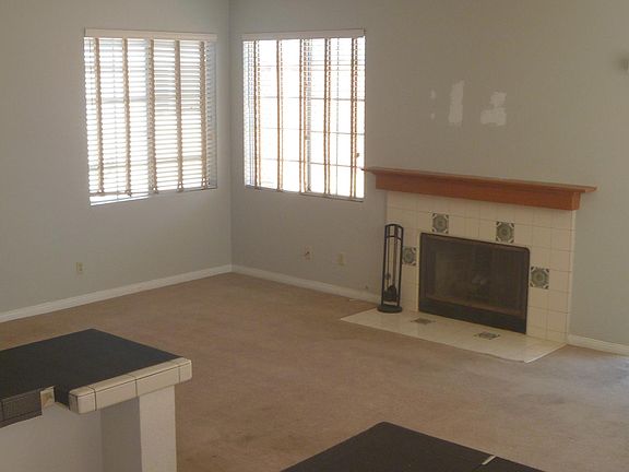 LIVING ROOM WITH NEW CARPETS. GAS FIREPLACE. DOOR TO LARGE PATIO DECK AT RIGHT. VIEW FROM WET-BAR.