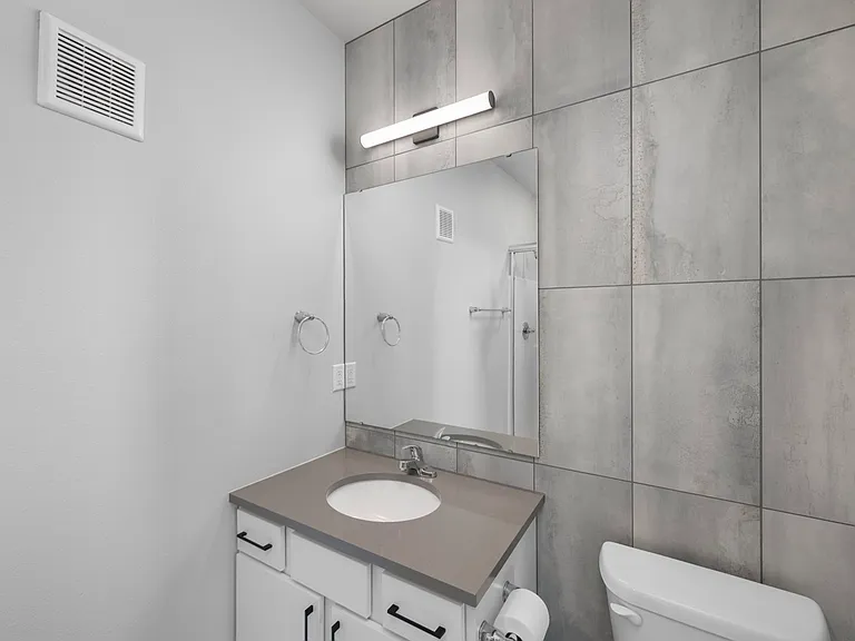 Modern bathroom with sleek gray tiles, stylish vanity, and bright lighting creating a fresh ambiance. Modern bathroom with sleek gray tiles, stylish vanity, and bright lighting creating a fresh ambiance.