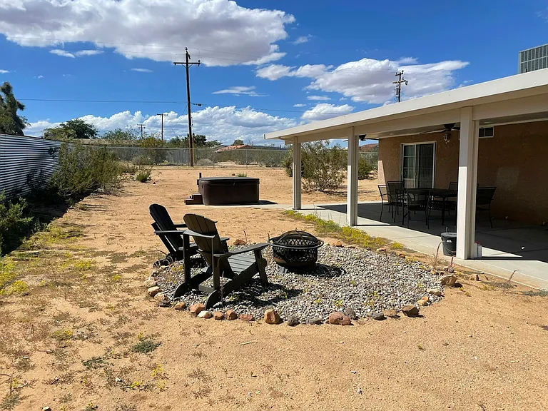 Backyard with new patio cover including ceiling fans, fire pit and hot tub