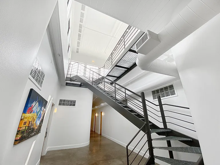 Stairs in Common Hallway to Panoramic Roof Deck Overlooking the River and Downtown Skyline