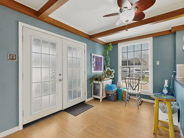 An eat-in area beside the kitchen with a tall window and a ceiling fan, enhancing the cozy ambiance.