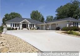Summer view of front of home with concrete driveway.