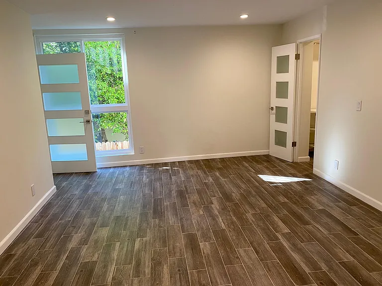 Large bedroom with walk in closet and entrance to balcony.