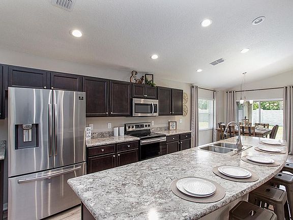 Open kitchen with Counter-height Island - New home for sale in Lake Alfred, FL. Photo showcases the