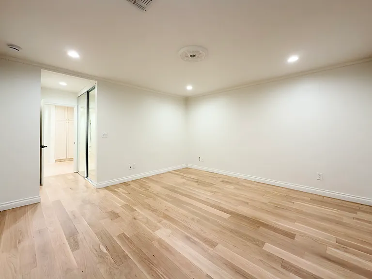 Unfurnished bedroom with an open doorway to a private bathroom offers convenience in this Beverly Hills luxury rental at 1094 Garden Lane, a 90210 lease.