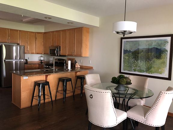 Kitchen open to dining, living room and patio. Views of willows and pond.